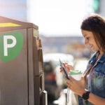 Driver using a parking pay station to purchase parking access in a commercial parking facility.