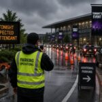 Parking operations staff coordinate traffic during rainy weather at a busy event venue, adapting parking operations to changing conditions and maintaining safe vehicle flow.