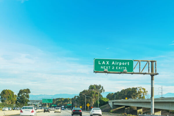 Highway sign directing drivers to Los Angeles International Airport (LAX) along a Southern California freeway.